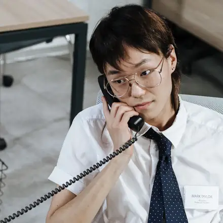 A billing specialist on the phone at his desk