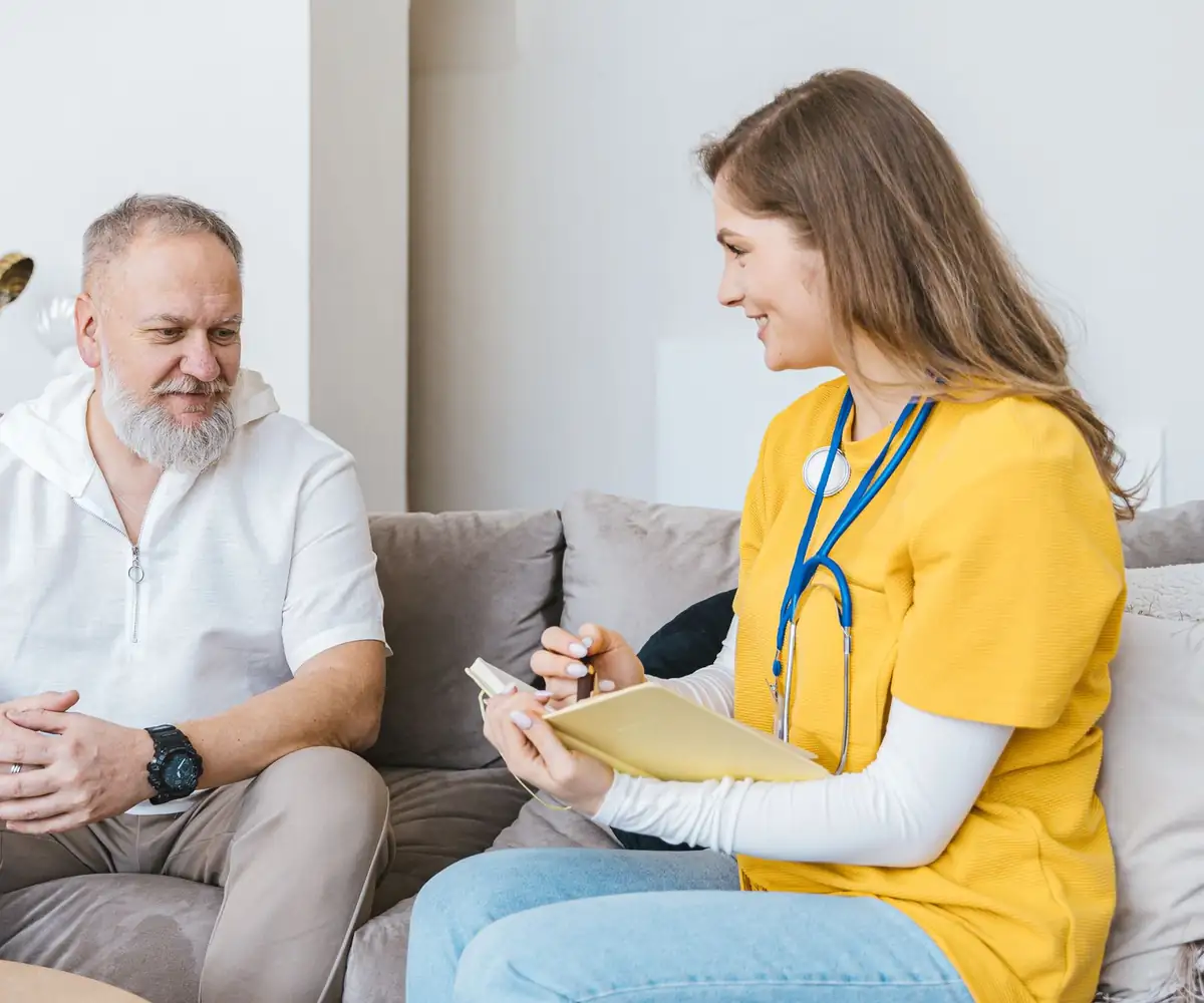A nurse practitioner taking notes with a patient