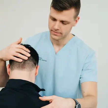 A physical therapist working on a patient’s neck and shoulder